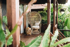 烏魯瓦圖的住宿－White Tortoise Eco Villa's，门廊上的藤椅