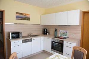 a kitchen with white cabinets and a stove top oven at Ferienwohnung Abracadabra in Bad Pyrmont