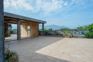 a house with a large patio with mountains in the background at RedDoorz Syariah near Universitas Negeri Gorontalo 2 in Gorontalo