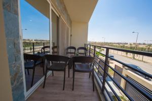 a balcony with tables and chairs and a view of a street at The Home Dreamland in 6th Of October