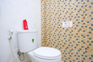 a bathroom with a white toilet and a shower curtain at RedDoorz Syariah near Universitas Negeri Gorontalo 2 in Gorontalo