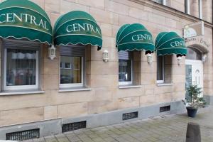 a building with green awnings on the side of it at Pension Central Nuernberg-Fuerth in Fürth