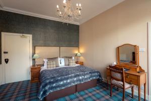 a bedroom with a bed and a mirror and a chandelier at The Albany St Andrews in St Andrews