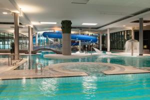 an indoor swimming pool with a water slide at Quality Hotel Sarpsborg in Gralum