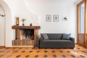 - un salon avec un canapé et une cheminée dans l'établissement Residenza Ariosto Depandance by Studio Vita, à Bologne