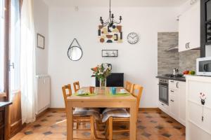 eine Küche und ein Esszimmer mit einem Holztisch und Stühlen in der Unterkunft Residenza Ariosto Depandance by Studio Vita in Bologna