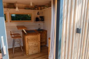 una cucina in una piccola casa con un bancone e uno sgabello di Tiny House Steirermadl a Birkfeld