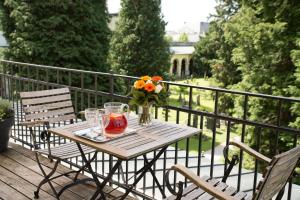 einen Holztisch mit einer Vase aus Blumen auf dem Balkon in der Unterkunft Boutiquehotel Amadeus in Salzburg