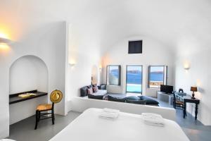 a bedroom with a bed and a desk and a couch at Grand Ambassador Santorini Hotel in Akrotiri