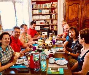 a group of people sitting around a table eating at Les rêves d'Angèle in Crain +41 photos
