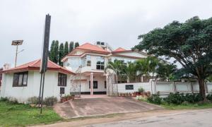 a white house with a red roof at Bota Royal in Kushālnagar