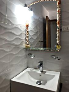 y baño con lavabo blanco y espejo. en Fully Equipped New 1br Apt–dt–2mins To Beach, en Sosúa