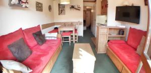 - un salon avec un canapé rouge et une table dans l'établissement Appartement La Plagne Soleil, à La Plagne