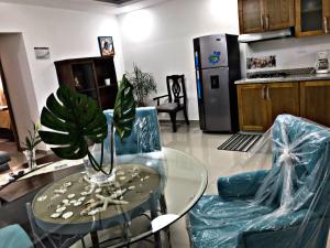cocina con mesa de cristal y 2 sillas azules en Fully Equipped New 1br Apt–dt–2mins To Beach, en Sosúa