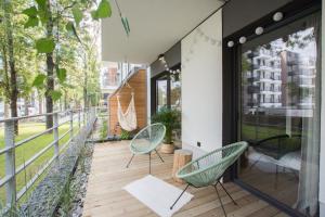 a balcony with two chairs and a hammock at Rakowicka Apartment in Krakow