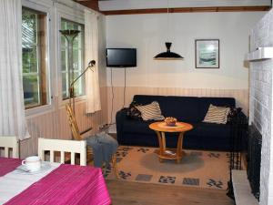 een woonkamer met een bank en een tafel bij Tervakosken Tervaniemi hirsimökki & oma sauna in Tervakoski