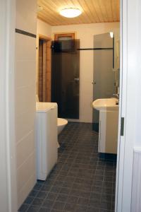 a bathroom with a tub and a toilet and a sink at Tervakosken Tervaniemi hirsimökki & oma sauna in Tervakoski