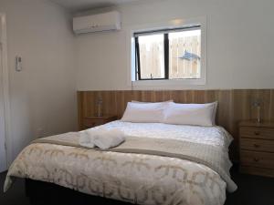 Un dormitorio con una cama con una toalla. en Owens Motel, en Dunedin