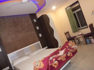 ein Schlafzimmer mit einem Bett mit einer roten Decke darauf in der Unterkunft Exotic Stay Near Shivaji Marg in Mount Ābu