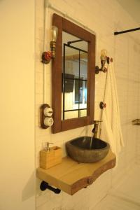 a bathroom with a stone sink and a mirror at Lombera Apartamentos in Arnedillo