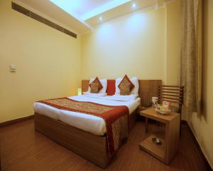 um quarto de hotel com uma cama e uma mesa em The Pearl- A Royal Residency em Nova Deli