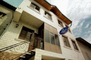 a building with a balcony and a blue sign on it at Ismail in Bukhara