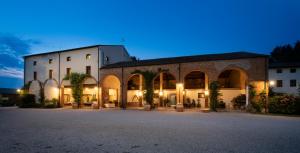 a large brick building with a courtyard at night at AGRITURISMO LA CAMPAGNOLA in Montegaldella