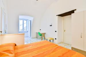 - une chambre avec un lit orange et une table dans l'établissement Della Monica Rooms, à Vietri
