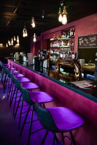 a bar with purple stools in front of a counter at Centrum Hotel in Akureyri