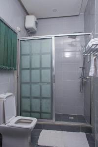 a bathroom with a glass shower with a toilet at Twenty Hotel in Kaduna