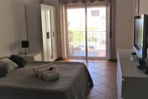 アルマカオ・デ・ペラにある4D Terrace - Casas & Papeisのベッドルーム1室(タオル付きのベッド1台付)
