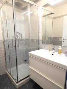 bagno bianco con doccia e lavandino di La casa del Centro a Modena