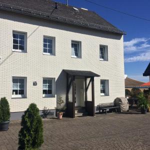 a white brick house with a black roof at Ferienhaus Weins in Lieg