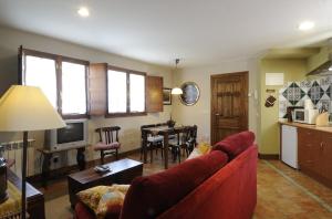 un soggiorno con un divano rosso e un tavolo di Apartamentos Casa María Juanín a Collanzo