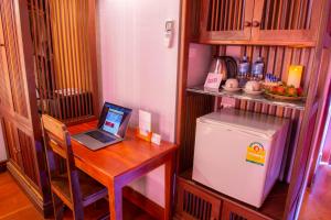 a kitchen with a desk with a laptop and a refrigerator at Muangthong Boutique Hotel in Luang Prabang