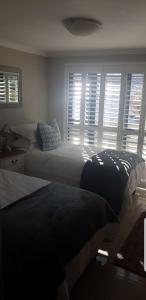 a bedroom with two beds and a window with blinds at Waterfront - Lagoon Terrace Nr.17 in Knysna