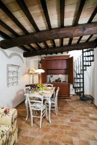 ein Esszimmer mit Tisch und Stühlen und eine Küche in der Unterkunft La Corte De' Vasari in Bevagna + 20 Fotos