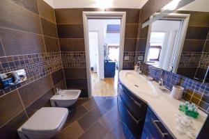 uma casa de banho com um lavatório, uma banheira e um WC. em King Of The Lake em Riva del Garda