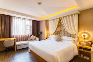una habitación de hotel con una gran cama blanca y una silla en Beijing Red Hotel, en Beijing