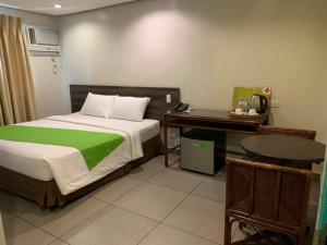 a bedroom with a bed and a desk and a table at Cebu R Hotel Mabolo in Cebu City