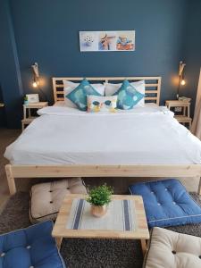 1 dormitorio con 1 cama grande y paredes azules en Thira House, en Karon Beach