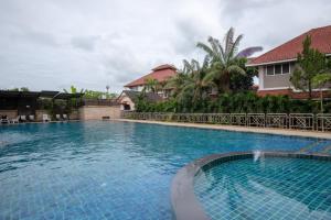 a large swimming pool in front of a house at Pimann Inn Hotel in Chiang Rai