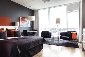 a bedroom with a bed and chairs and a table at Sky Hotel Apartments Tornet in Linköping
