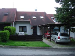 una casa con un coche aparcado delante de ella en Ubytování Duškovi, en Lipno nad Vltavou