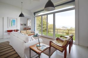 a living room with a white couch and chairs at ATeRIAN LAZKANO ENEA in Getaria