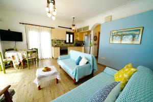 - un salon avec un canapé bleu et une table dans l'établissement Apartment Vana, à Metamórfosi