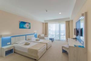 Habitación de hotel con 2 camas y TV en DIT Evrika Beach Club Hotel - All Inclusive, en Sunny Beach