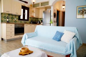 a living room with a blue couch in a kitchen at Apartment Vana in Metamorfosi