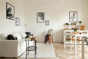 uma sala de estar com um sofá branco e uma mesa em A casa mia em Saronno