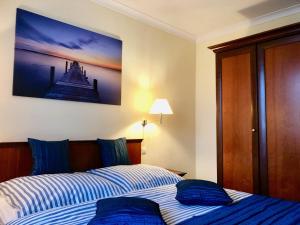 a bedroom with a bed and a painting on the wall at Ferienwohnung Seeblick - Insel Usedom in Balm